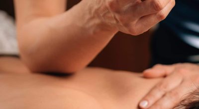 Deep Tissue Massage Therapy. Therapist massaging Woman’s Back, using Elbow Pressure.